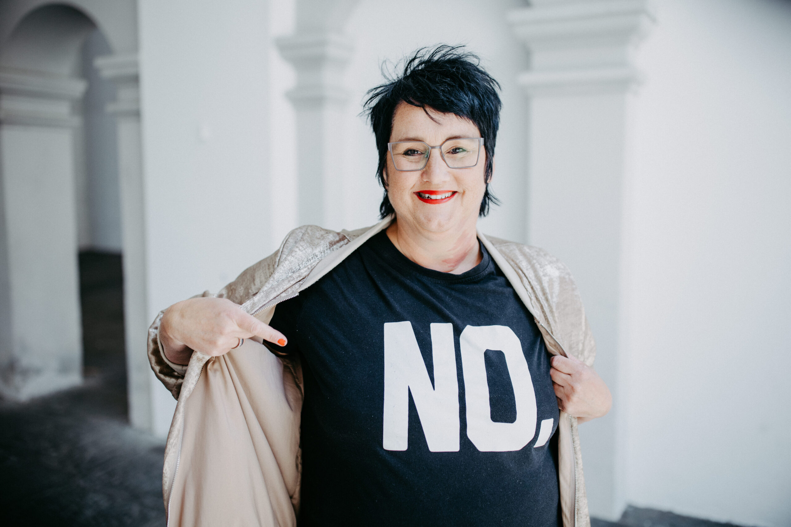 Sabine, Coach für Führungsfrauen steht mit einem schwarzen Tshirt auf dem NO steht in Ravensburg.