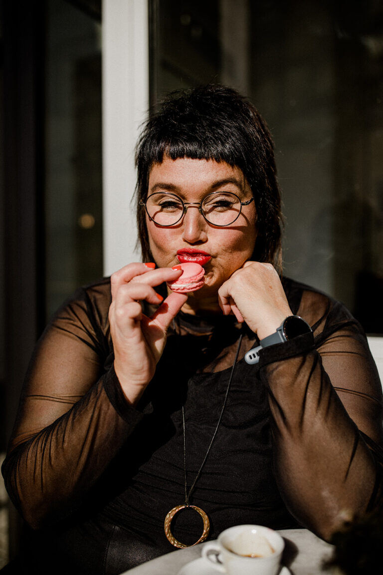 Sabine macht Pause und hält ein Macaron vor den Mund