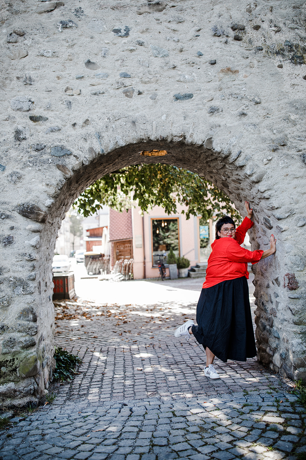 Sabine, die Coaching für Frauen ab 50 anbietet, lehnt an einem Stadttor in Wangen im Allgäu.